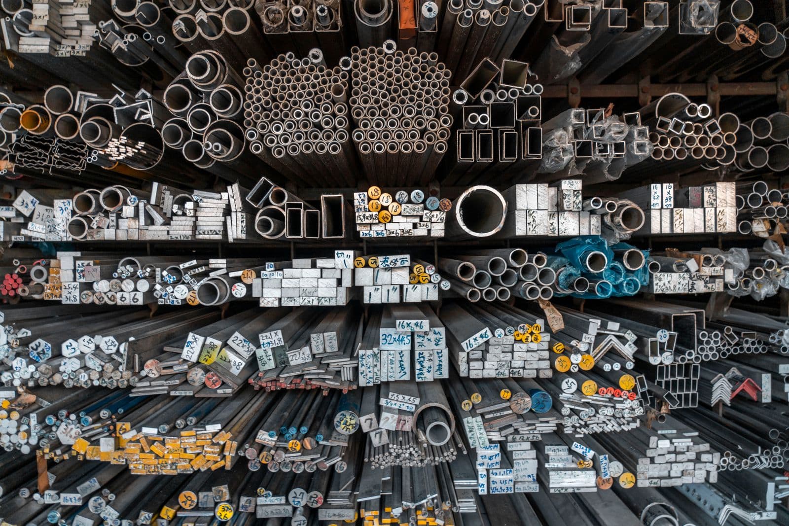 Metal bars, pipes, and tubing organized on industrial storage racks